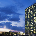 Night view of the complex with the iconic white shapes and the t